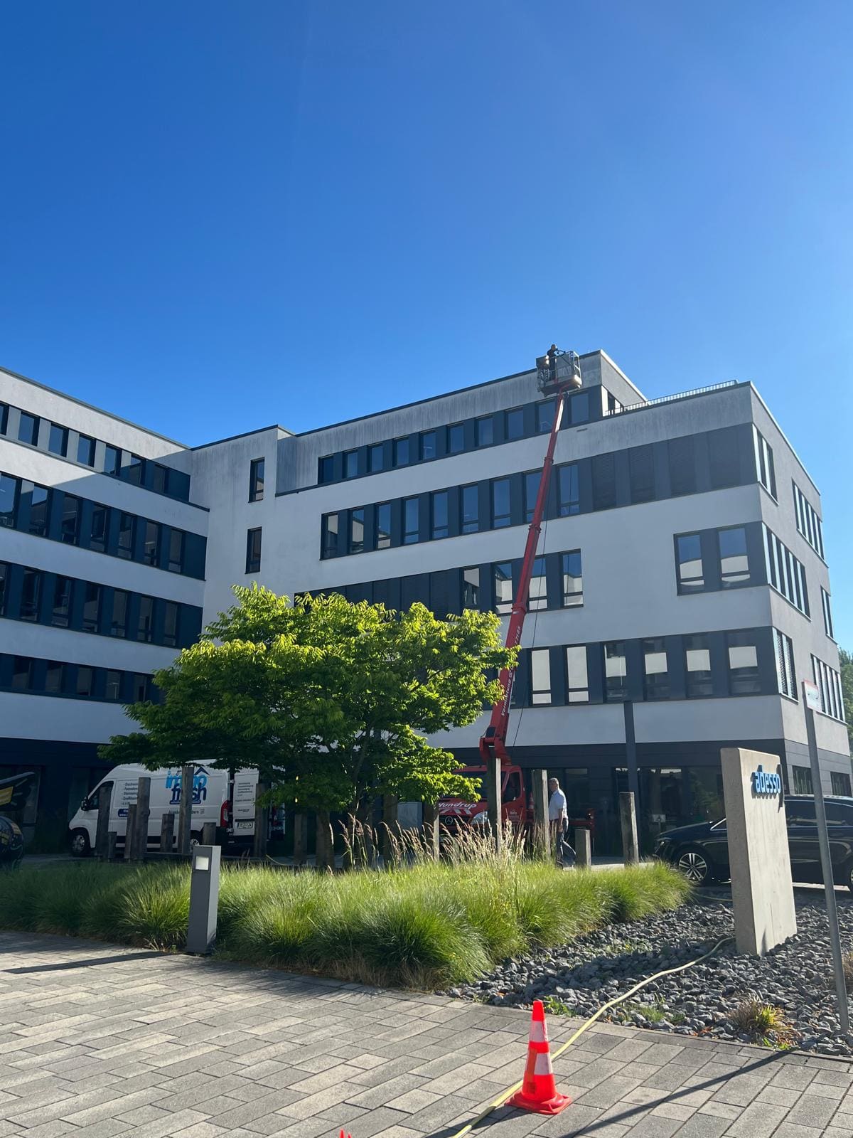 Hubarbeitsbühne reinigt die Fassade eines mehrstöckigen Bürogebäudes