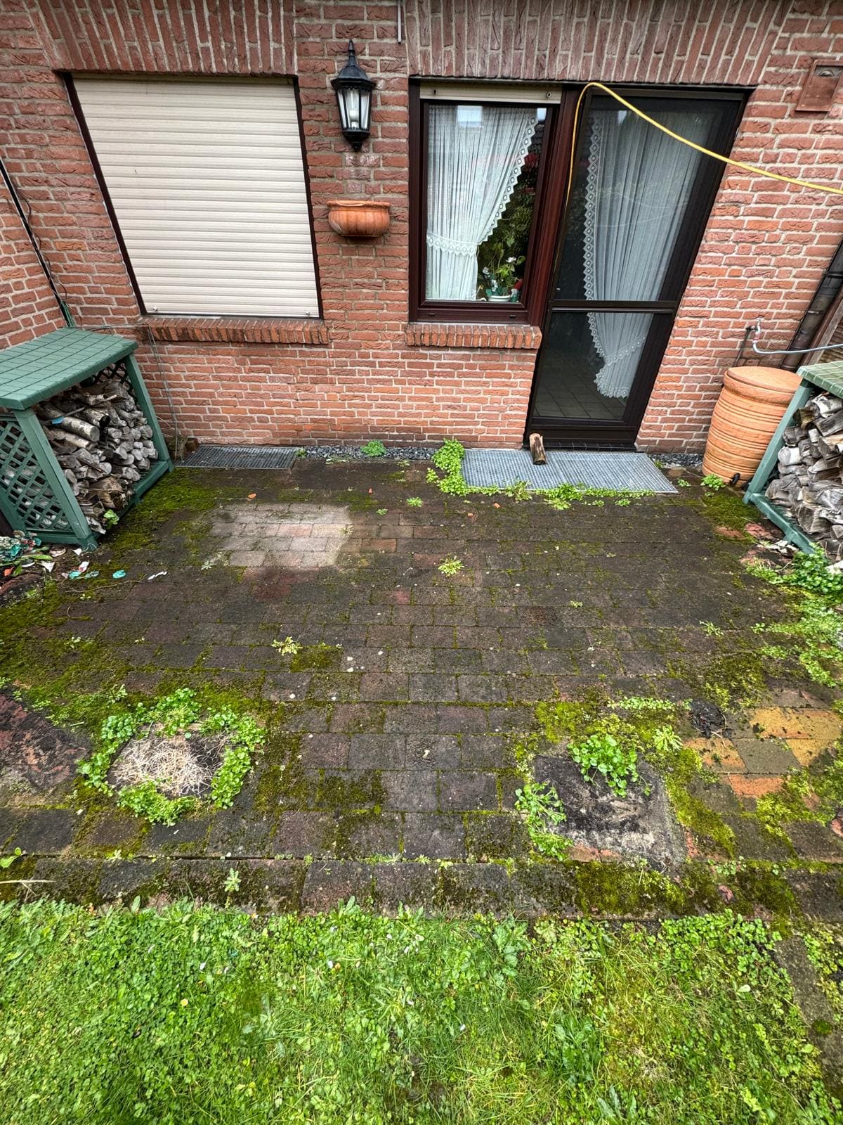 Terrassenpflaster vor der Reinigung mit dunklen Schmutzablagerungen