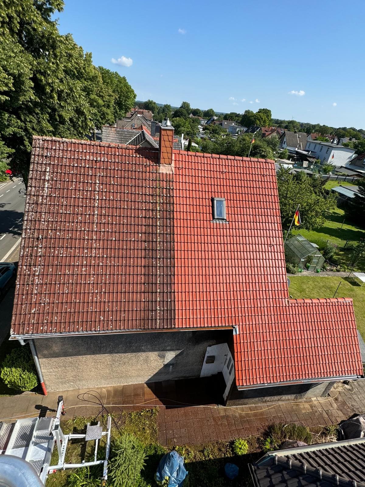 Dachreinigung in Recklinghausen mit Hubarbeitsbühne: die linke Dachhälfte ist noch bewachsen, die rechte bereits gereinigt
